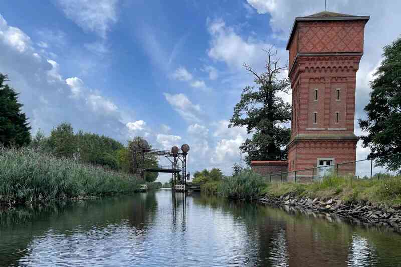 De watertoren uit 1879 en de Vapeurbrug uit het interbellum gezien langs de oostkant aan de Moervaart in Moerbeke