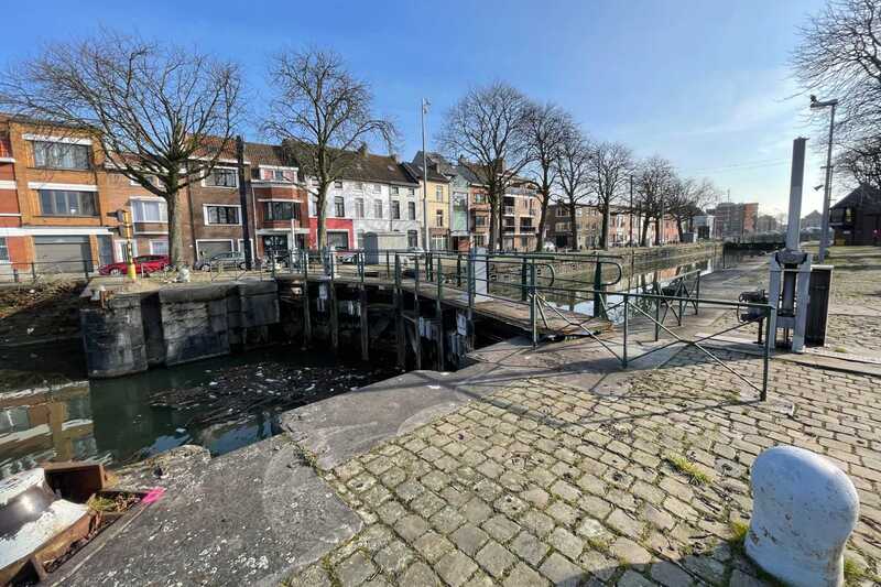 Tolhuissluis met veel drijfvuil aan de kant van het Kanaal Gent-Terneuzen